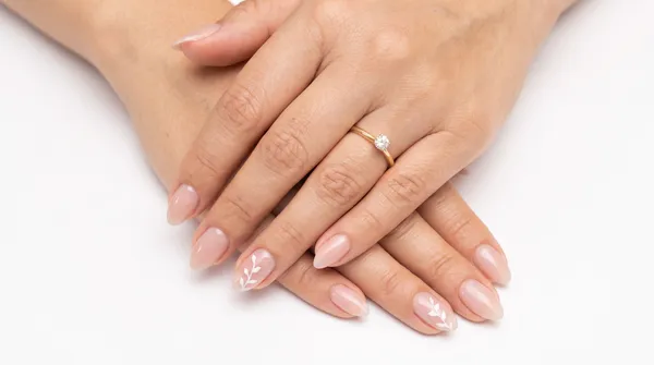 Manicure nude minimalista con acento de hoja blanca