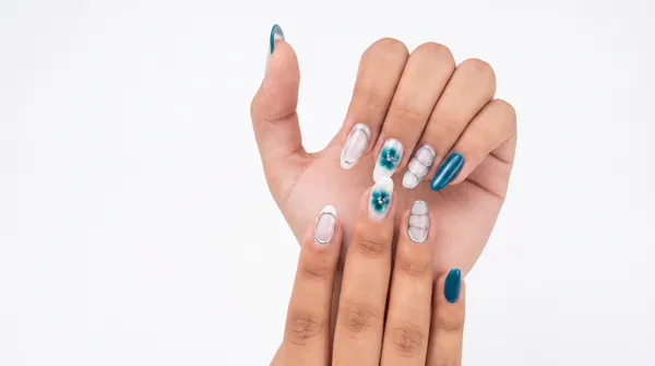 Nail art blanco y plata con acentos turquesa, líneas negativas y pedrería