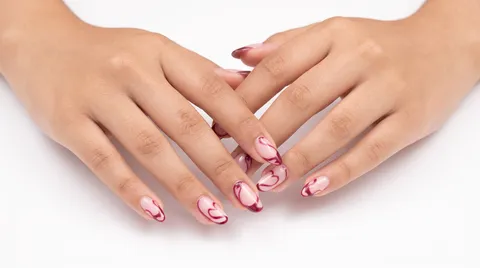 Nail art abstracto en tono vino sobre base rosa transparente